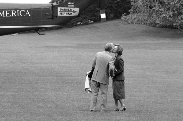President Jimmy Carter pauses to kiss his wife, first lady Rosalynn Carter, as he boards a helicopter in Washington