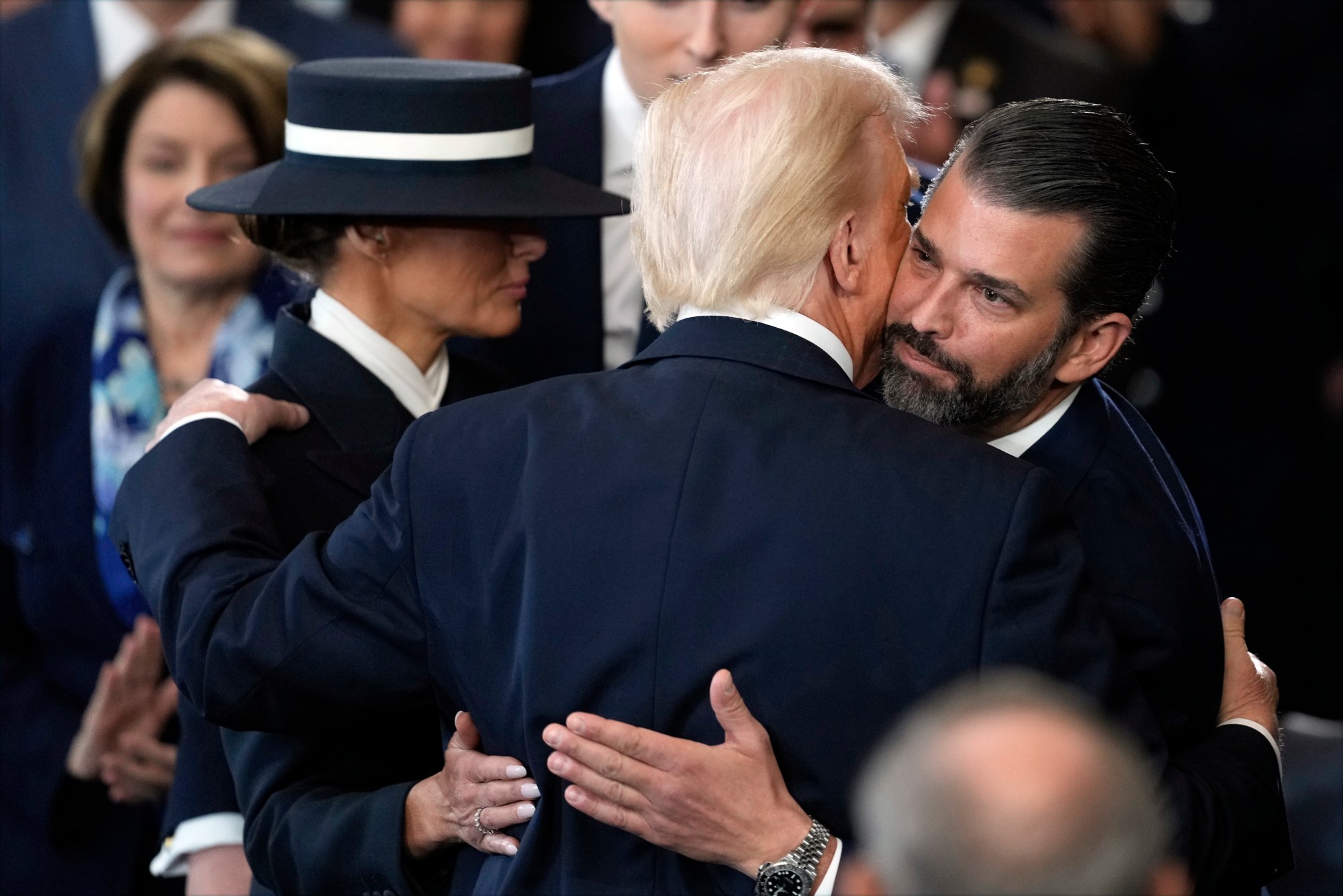 President Donald Trump hugs Donald Trump Jr., as he puts his arm around first lady Melania Trump after being sworn in during the 60th Presidential Inauguration in the Rotunda of the U.S. Capitol in Washington, Monday, Jan. 20, 2025. (AP Photo/Julia Demaree Nikhinson, Pool)