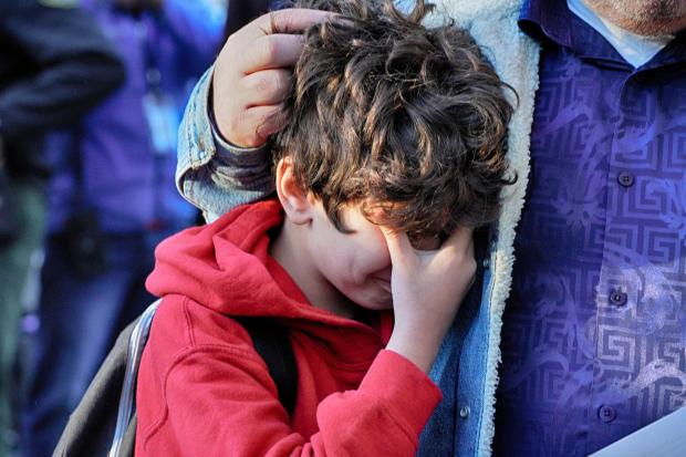 Palisades Charter Elementary School third grade student Jaden Koshki cries in his father's arm upon arriving at his new school