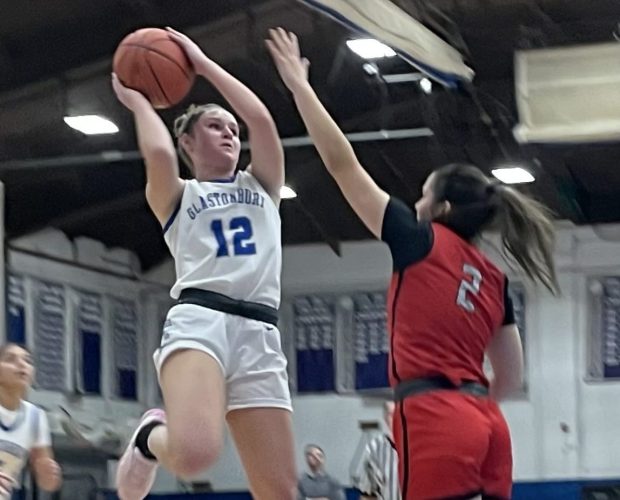 Glastonbury senior Madison Handrahan (12) takes a shot while being guarded by Conard's Emily Knowles (2) in Glastonbury's 49-42 win over Conard Tuesday night at Glastonbury High. (Photo by Lori Riley)