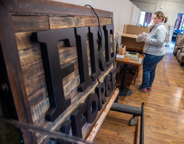 Becky McGuigan, Assistant Director at Forge City Works, works on unpacking decorations for the Fire by Forge restaurant on Broad Street in Hartford. (Aaron Flaum/Hartford Courant)