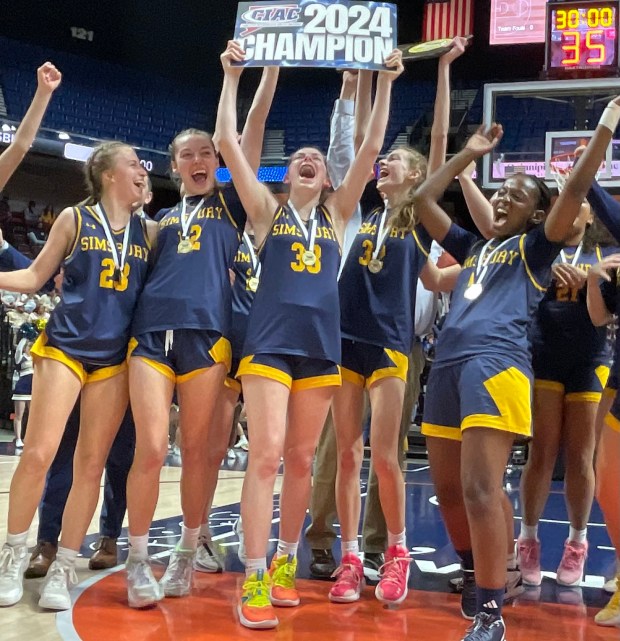 The Simsbury girls basketball team celebrates after beating Holy Cross 55-40 in the Class L championship game Saturday night at Mohegan Sun. (Photo by Lori Riley)