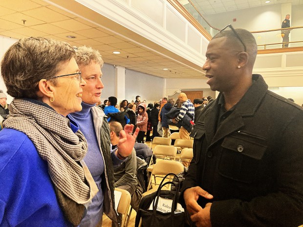 Tracey Wilson and Beth Bye talk with keynote speaker John Mills after West Hartford's Dr. Martin Luther King Jr. Dy celebration Monday at West Hartford town hall. (Don Stacom/The Hartford Courant)