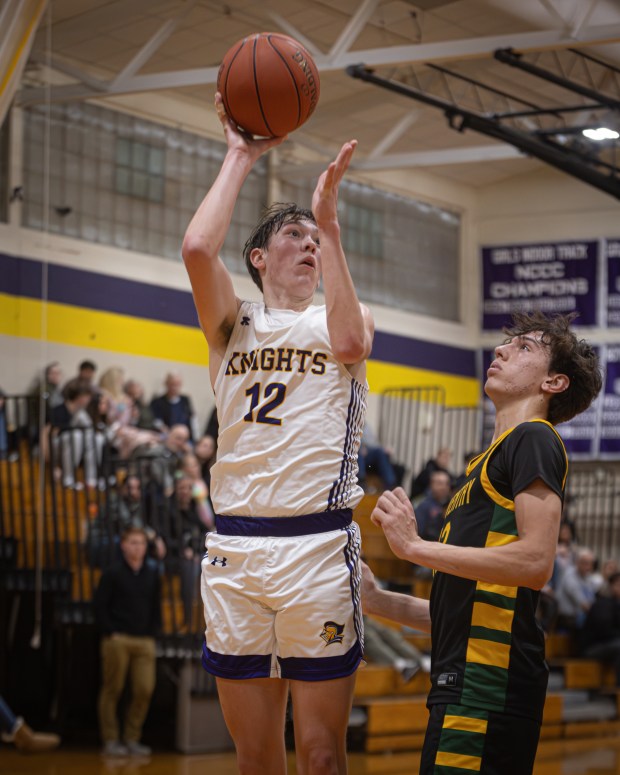 Ellington sophomore Jack Curtis (12) goes up for a shot against Coventry Friday night. Ellington won the NCCC game, 65-50. (Photo by David Lenz)