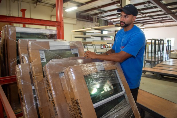 Michael Hunt, Lead Warehouse Coordinator, organizes windows for a job at the Advanced Window Systems LLC warehouse at his office in Cromwell on Wednesday, Aug. 14, 2024. (Aaron Flaum/Hartford Courant)