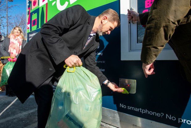 Bristol Mayor Jeffrey Caggiano scans an app on his phone at a CLYNK redemption container at the Stop and Shop parking lot along Farmington Ave. in Bristol before depositing a bag of recyclables on Tuesday, Jan. 14, 2025. (Aaron Flaum/Hartford Courant)