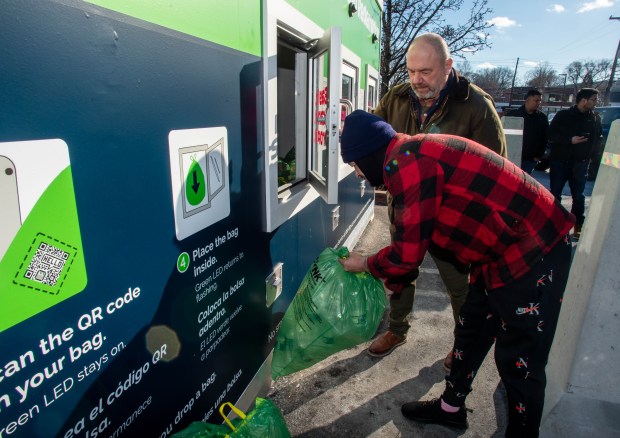 Dan Kiley, from CLYNK, helps David Gonzalez of Bristol, deposit his first bags of recyclables at a CLYNK redemption container at the Stop and Shop parking lot along Farmington Ave. in Bristol on Tuesday, Jan. 14, 2025. (Aaron Flaum/Hartford Courant)