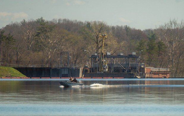 A boat passes the Rainbow Dam at the Rainbow Reservoir in Windsor on Monday, April 15, 2024. The water from the Farmington River is controlled by the Rainbow Dam. (Aaron Flaum/Hartford Courant)