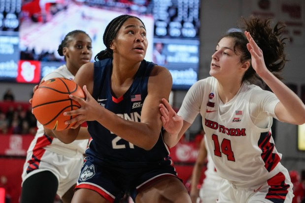 St. John's Kylie Lavelle (14) defends UConn's Sarah Strong (21) during the second half of an NCAA women's college basketball game, Wednesday, Jan. 15, 2025, in New York. (AP Photo/Frank Franklin II)